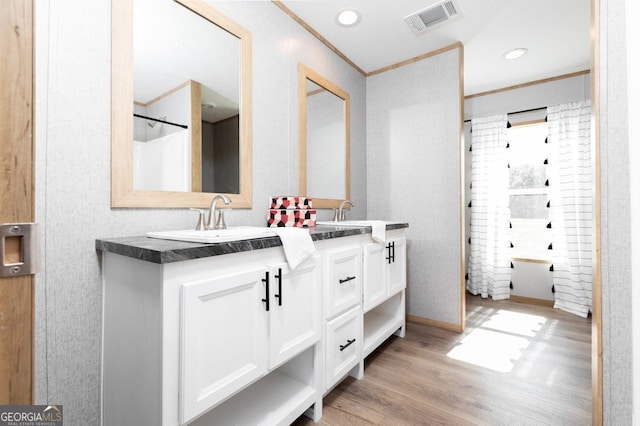 bathroom featuring shower / bath combo with shower curtain, wood-type flooring, vanity, and crown molding