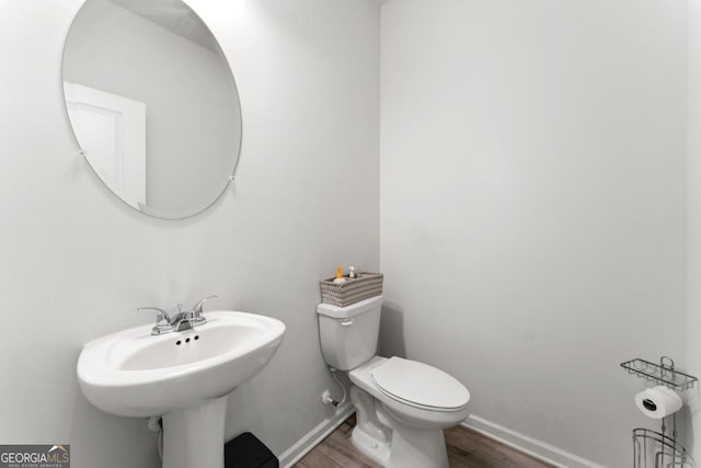 bathroom with hardwood / wood-style flooring and toilet