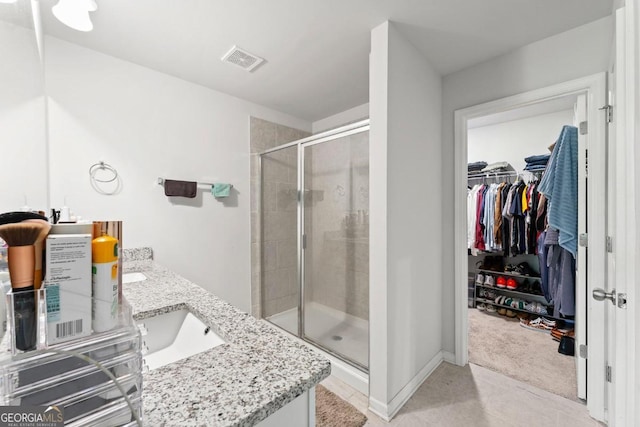 bathroom featuring tile patterned flooring, vanity, and an enclosed shower