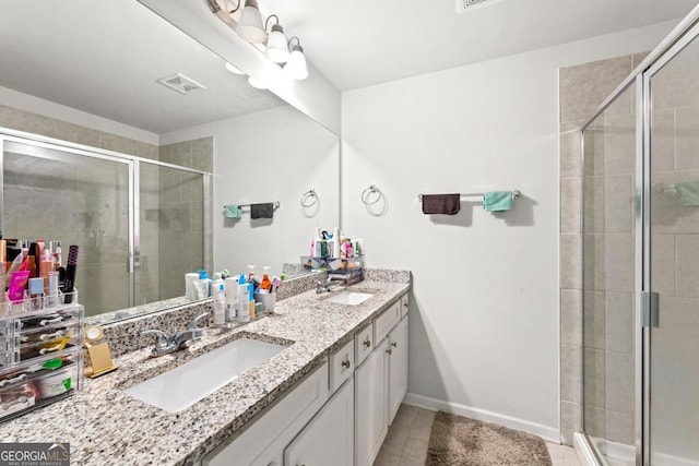 bathroom featuring an enclosed shower, vanity, and tile patterned flooring