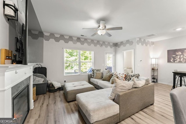 living room with light wood-type flooring and ceiling fan