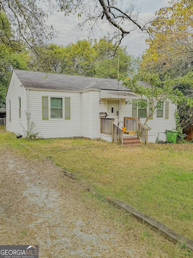 single story home with a front lawn and a deck