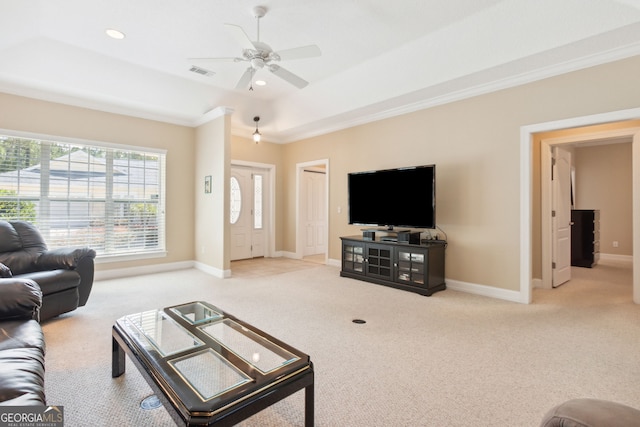 carpeted living room with ceiling fan, a tray ceiling, and ornamental molding