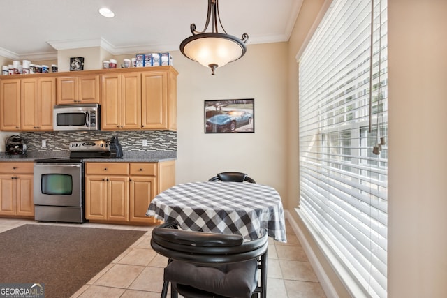 kitchen with ornamental molding, appliances with stainless steel finishes, light tile patterned floors, and pendant lighting