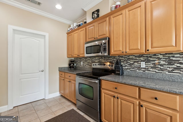 kitchen with appliances with stainless steel finishes, tasteful backsplash, dark stone countertops, light tile patterned floors, and crown molding