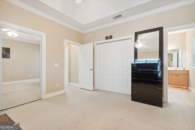 unfurnished bedroom with ornamental molding, ensuite bath, ceiling fan, and light colored carpet