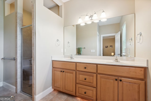 bathroom featuring a shower with shower door, vanity, and tile patterned flooring