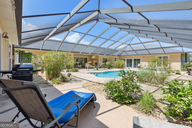 view of pool featuring a lanai, a grill, and a patio area