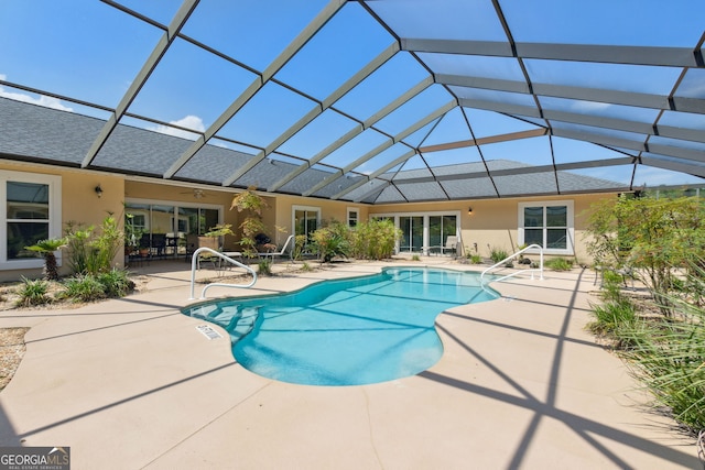 view of pool with glass enclosure and a patio