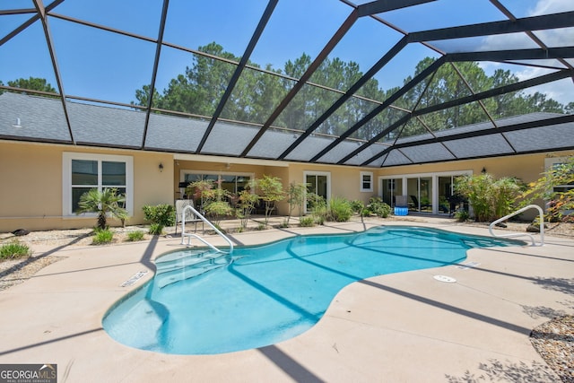 view of swimming pool with glass enclosure and a patio