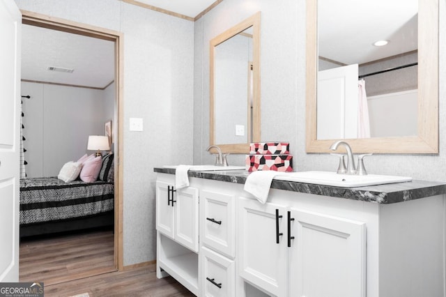646 Grande Ave, Folkston, GA 31537 - bathroom with wood finished floors, double vanity, connected bathroom, and ornamental molding