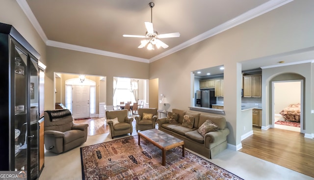 living room featuring ceiling fan, ornamental molding, and light hardwood / wood-style flooring