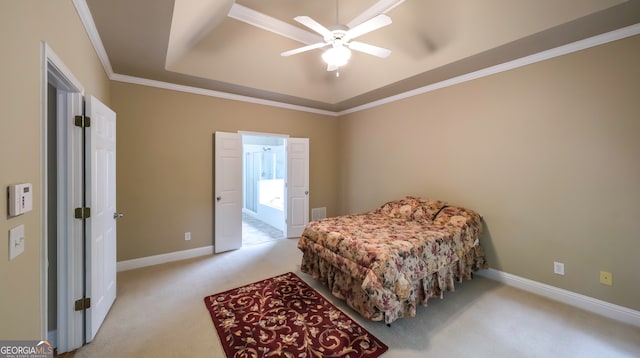 carpeted bedroom with ensuite bath, a raised ceiling, ceiling fan, and crown molding