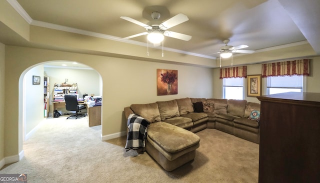 living room with ceiling fan, built in desk, ornamental molding, and light carpet