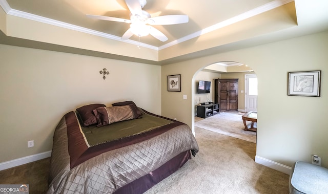 bedroom with carpet flooring, a tray ceiling, ceiling fan, and ornamental molding