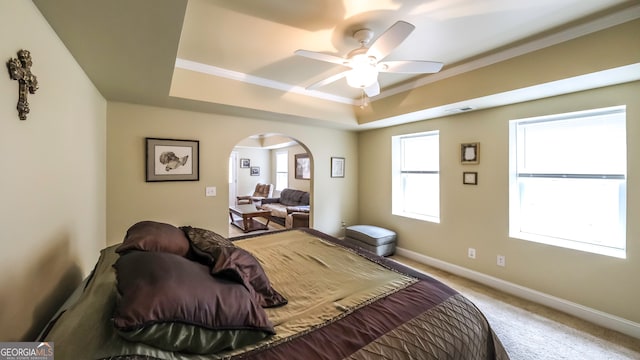 bedroom with carpet, ceiling fan, a raised ceiling, and ornamental molding