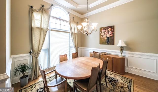 dining room with a chandelier, wood-type flooring, and ornamental molding