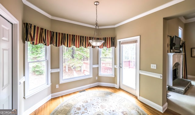 interior space with crown molding and light hardwood / wood-style flooring