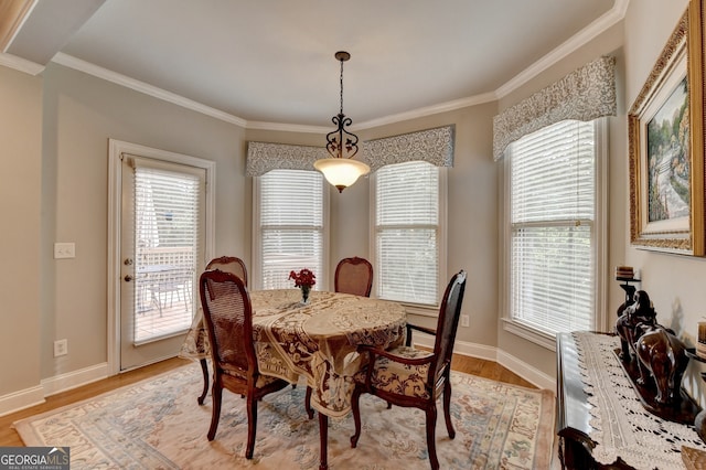 dining area featuring light wood-type flooring, a wealth of natural light, and crown molding