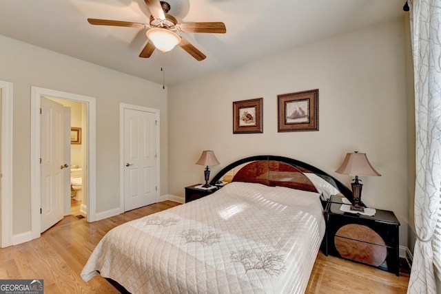 bedroom featuring light wood-type flooring, ceiling fan, and ensuite bathroom