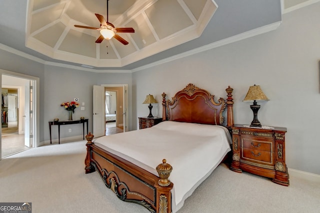 carpeted bedroom with ceiling fan, crown molding, and a tray ceiling