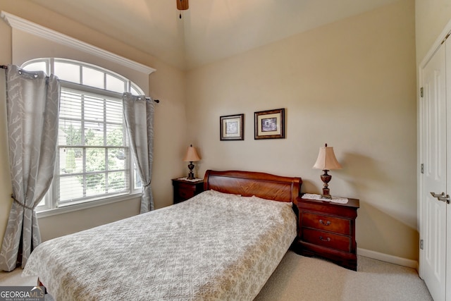 bedroom with ceiling fan, multiple windows, and light carpet