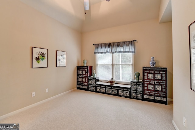 interior space featuring ceiling fan, carpet flooring, and lofted ceiling