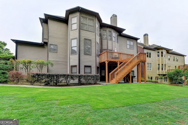 rear view of house with a lawn and a wooden deck