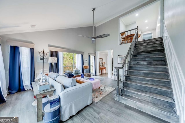 living room with ornate columns, wood-type flooring, lofted ceiling, and ornamental molding