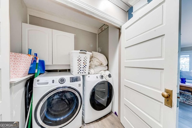 clothes washing area with light hardwood / wood-style floors, ornamental molding, and washing machine and clothes dryer