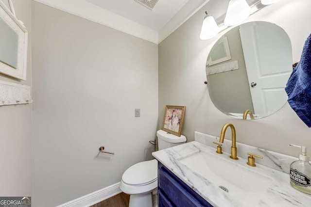 bathroom featuring hardwood / wood-style flooring, vanity, toilet, and crown molding