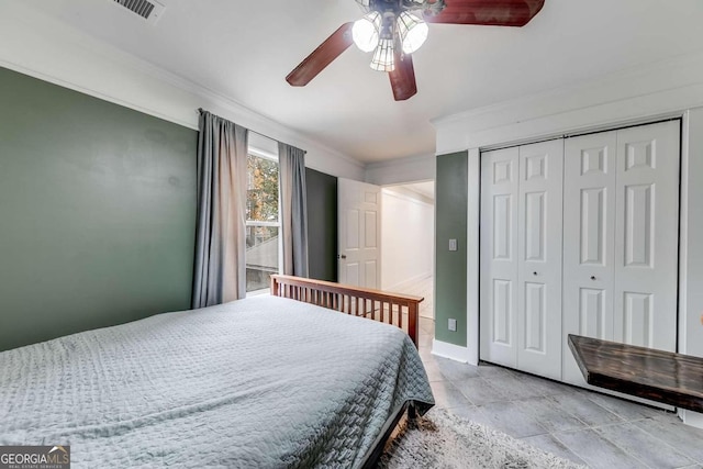 bedroom with ceiling fan, crown molding, and a closet