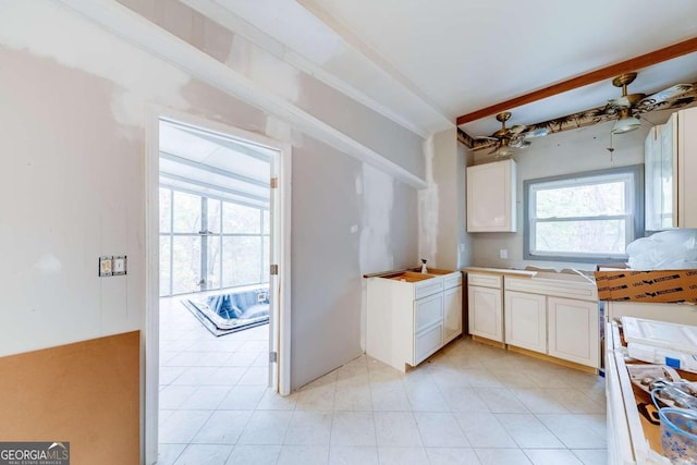 kitchen with white cabinets, ceiling fan, and beam ceiling