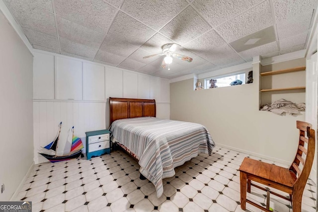 bedroom featuring ceiling fan and a drop ceiling