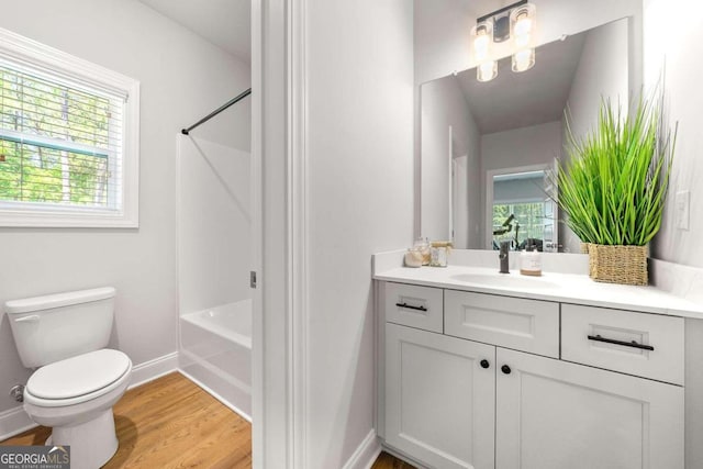 full bathroom with vanity, hardwood / wood-style flooring, a healthy amount of sunlight, and toilet