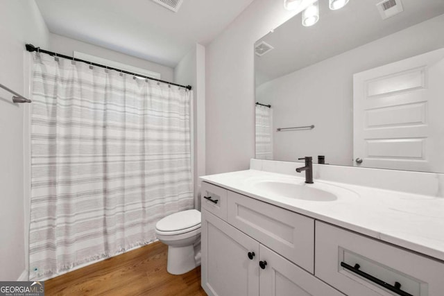 bathroom with wood-type flooring, toilet, and vanity