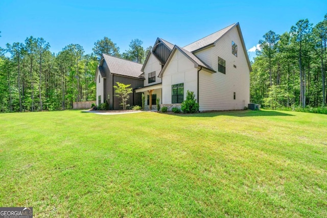 back of property featuring central AC and a yard