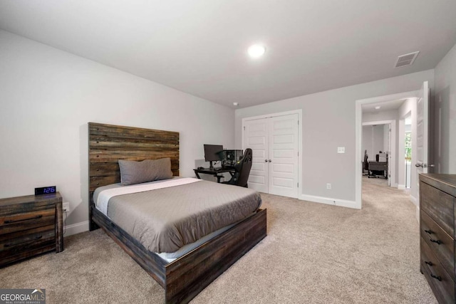 bedroom featuring light carpet and a closet