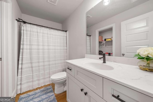 bathroom featuring wood-type flooring, vanity, and toilet