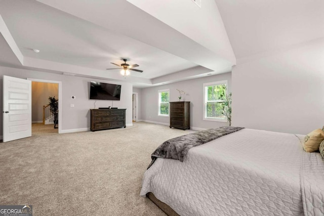 bedroom featuring carpet floors, ceiling fan, and a raised ceiling