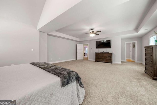 bedroom with carpet floors, ceiling fan, and a raised ceiling