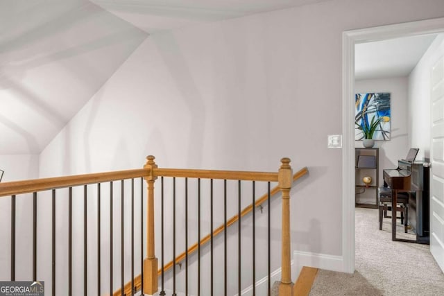 hallway featuring carpet flooring and lofted ceiling