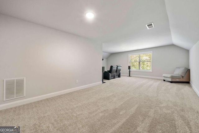 interior space with carpet flooring and vaulted ceiling