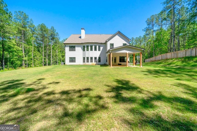 back of property with a lawn and a patio area