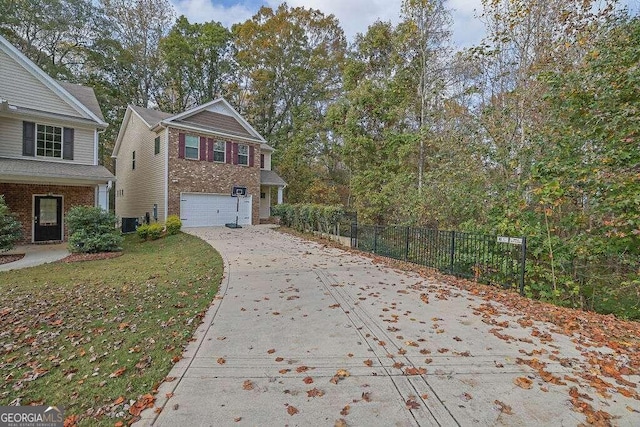 view of front facade with driveway, a garage, fence, a front lawn, and brick siding