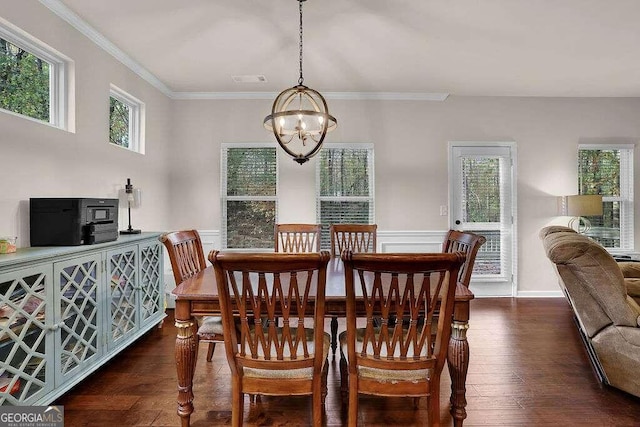 dining room with a chandelier, dark wood-type flooring, wainscoting, and crown molding