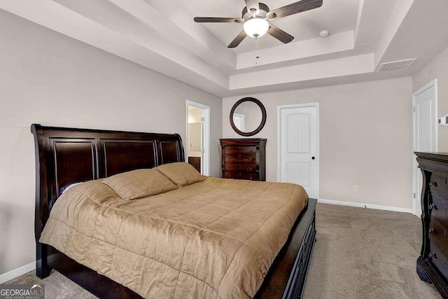 bedroom with carpet, a raised ceiling, visible vents, and baseboards