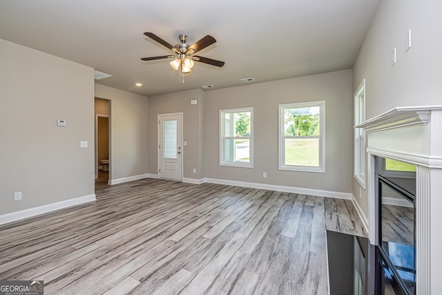 unfurnished living room featuring ceiling fan and light hardwood / wood-style floors