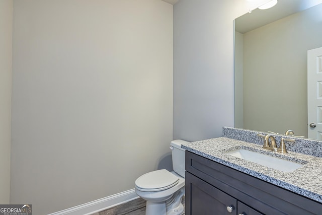 bathroom featuring vanity, toilet, and wood-type flooring