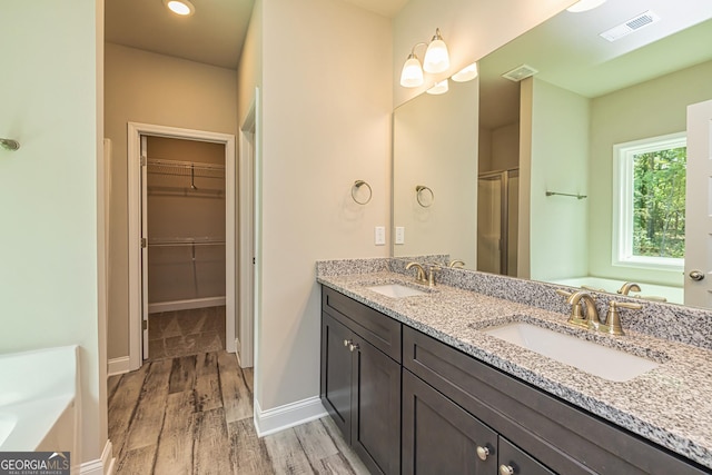 bathroom featuring vanity, separate shower and tub, and hardwood / wood-style floors